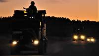 Ein Soldat auf einem Fahrzeug bei Abenddämmerung
