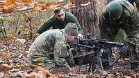 Die Trainingsteilnehmer bauen einen Kampfstand für das Maschinengewehr auf Lafette.