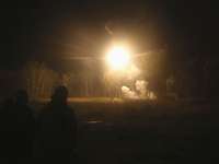 Vorfeldbeleuchtung Am Himmel sieht man die Vorfeldbeleuchtung vor einem Waldstück mit einem Lichtblitz.