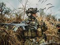 Bewaffneter Soldat im Gebüsch