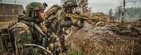 Zwei bewaffente Soldaten hinter Schutzwall