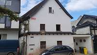 An der weißen Wand eines zerstörten Hauses sind Pegelstände der vergangenen Hochwasserereignisse angeschlagen