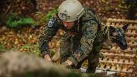 Ein Soldat mit einem Hund auf dem Rücken steigt eine Leiter hoch