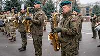 Soldaten spielen auf Instrumenten und stehen nebeneinander.