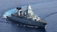 Ein graues Kriegsschiff befindet sich bei gutem Wetter in See.