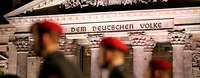 Soldaten (unscharf) vor dem Reichstag mit der Inschrift „Dem deutschen Volke“