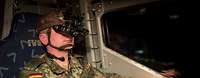 Fahren bei Nacht mit der Bildverstärkerbrille querschnittlich Ein Soldat mit Nachtsichtbrille sitzt am Steuer eines Fahrzeugs.