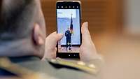 Ein Teilnehmer fotografiert den Preisträger mit seinem Smartphone