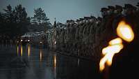 In Formation angetretene Soldatinnen und Soldaten in der Dämmerung