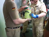 Teamwork! Mehrere Soldaten reichen eine Dose mit Lebensmitteln weiter