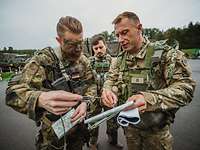 Ein deutscher und ein niederländischer Soldat schauen gemeinsam auf eine Karte und besprechen sich.