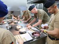 Teamwork in der Kombüse Mehrere Soldatinnen und Soldaten stehen in der Kombüse beim Plätzchen backen