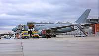 Zwei Rettungsfahrzeuge stehen vor einem Transportflugzeug Airbus A310 MedEvac auf einem Flughafen.