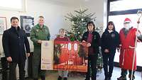 Mehrere Personen stehen bei einer Spendenübergabe an die Neuburger Tafel e.V. von der Bundeswehr nebeneinander.