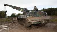 Ein Bundeswehr-Bergepanzer stehend im Gelände.