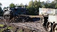 Ein Bergepanzer zieht einen Panzer.