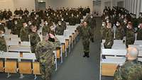 Soldaten in einem großen Saal. Ein Soldat meldet einem General die Truppe.