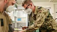 Ein Truppenarzt misst den Blutdruck bei einem Soldaten