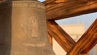 Eine Glocke hängt in einem Holzgestell