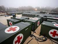 Aufbau eines Rettungszentrums Role 2 E Mehrere Container und Zelte mit Sanitätskreuz stehen verbunden miteinander auf einem Platz.