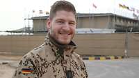 Ein Soldat steht vor einem abgezäunten Gebäude