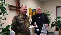 Hauptmann Heiko Krüger bedankt sich bei Militärpfarrer Uwe Stegen