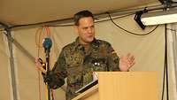 Ein Soldat steht in einem Gefechtszelt an einem Rednerpult.