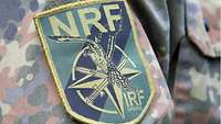 Ein Patch auf einem Ärmel einer Feldbluse mit dem Logo der NATO Response Force.