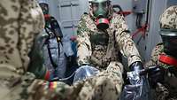 Mehrere Soldaten stehen in Schutzkleidung beieinander