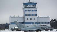 Ein Eurofighter steht im Schnee vor dem Tower der Airbase in Ämari, Estland