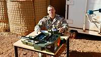 Ein Soldat sitzt an einem Tisch und zählt Munition