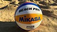 Ein Spielball liegt im Sand
