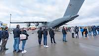 Mehrere Personen stehen Schlange vor einem Airbus