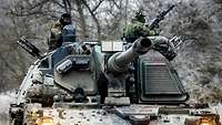 Panzerhaubitze frontal. Zwei Soldaten stehen bewaffnet in den Dachluken.