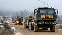 Zwei Lkw mit Tanksattelauflieger auf einer Sandpiste