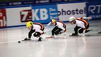 Drei Sportlerinnen und Sportler beim Shorttrack in voller Aktion.