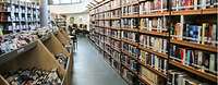 Blick in eine Bibliothek mit vielen Regalen und Büchern