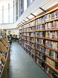 Blick in eine Bibliothek mit vielen Regalen und Büchern