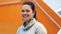Eine dunkelhaarige Frau lächelt in die Kamera