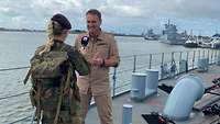 Kapitän wird an Bord seines Schiffes interviewt