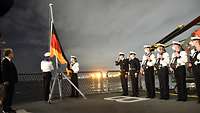 Soldaten der Marine stehen im Dienstanzug angetreten an Deck der Fregatte