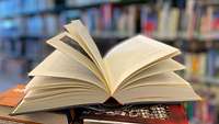 Ein aufgeklapptes Buch in einer Bücherei.