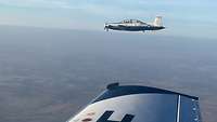 Eine Beechcraft T-6 im Formationsflug. Von der zweiten Maschine ist ein Stück der Tragfläche zu sehen.