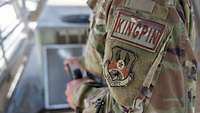 Am Oberarm trägt ein Soldat auf seiner Uniform zwei Patches mit der Aufschrift „KINGPIN“ und „USAFCENT“