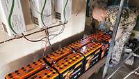 Ein Soldat schließt mehrere Blockbatterien für einen Aufzug an
