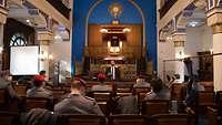 Ein Rabbiner spricht in einer Synagoge vor Soldaten im Dienstanzug.