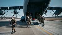 Soldaten steigen aus einem Transportflugzeug 