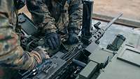 Zwei Soldaten arbeiten an einer geöffneten Waffenanlage des gepanzerten Fahrzeuges