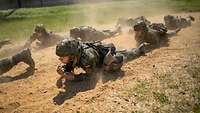Mehrere Soldaten kriechen auf dem Boden.