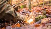 Ein Soldat entfacht ein Feuer mit einem Magnesium Feuerstarter.